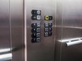Elevator lift buttons, modern stainless steel interior.