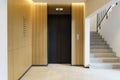Elevator in the lobby hall of an apartment building. Modern decor and wood finishing of the ground floor and entrance. Royalty Free Stock Photo