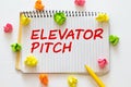 elevator pitch text message on white paper and office supplies, pen, paper note, on white desk Royalty Free Stock Photo