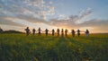 Eleven cheerful girls run to the meeting across the field in the summer, holding hands. Royalty Free Stock Photo