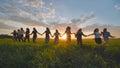 Eleven cheerful girls run to the meeting across the field in the summer, holding hands. Royalty Free Stock Photo