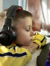 an eleven-year-old boy in headphones sits at the computer in the evening and plays games and studies