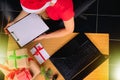 The elf receives an online e-mail by the kidney, and reads the list of gifts at the table with gift boxes. Christmas Royalty Free Stock Photo