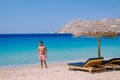 young guy on the beach of Mykonos, Elia beach Mikonos, Mykonos beach during summer with umbrella and luxury beach chairs Royalty Free Stock Photo