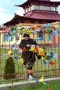 ELISTA, RUSSIA. The woman stands behind a fencing with color Buddhist prayful tags. Buddhist center of tradition Kagyu Karma