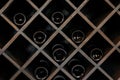 Elite dark glass wine bottles stacked on wooden racks in cellar, market, restaurant or home. Collection of bottles wine Royalty Free Stock Photo