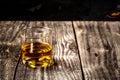 Elite drink for masculine relaxation. whiskey served on wooden planks. Vintage countertop with highlight and a glass of hard