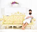 Elite leisure concept. Man on sleepy face in bathrobe, drinks coffee, in luxury hotel in morning, white background. Man
