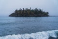 Ellingson Island on Lake Superior with large waves in foregound on a gloomy overcast day Royalty Free Stock Photo