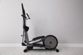 Elliptical machine cross trainer near light grey wall indoors