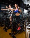 Elliptical walker trainer man and woman at black gym