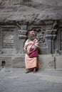 Sadhu, holy man sit in Ellora cave view carved in the rock wall near Aurangabad, Maharashtra, India