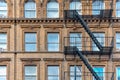 Ellow brick facade, and pair of boots hanging of the fire stairs. Chelsea, NYC