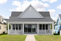 A large, grey ranch home with a covered porch.