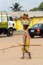 Unidentified Ghanaian woman in colored dress carries a basin on