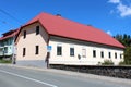 Elongated ground level family house with multiple windows in a row and new facade next to paved road and stone wall Royalty Free Stock Photo