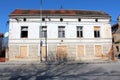 Elongated old abandoned suburban family house with boarded and broken windows on dilapidated cracked facade Royalty Free Stock Photo