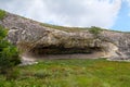 The elongated oval grotto in the rock and surrounded by the brig