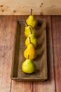 Five Williams pears on a wooden plate on a wooden table Royalty Free Stock Photo