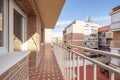 Elongated viewing terrace with white metal railing and views of a block patio