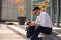 An eloquent businessman is outside, he is enjoying in the beautiful weather while looking at the notebook Royalty Free Stock Photo