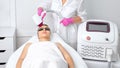 Elos epilation hair removal procedure on the face of a woman. Beautician doing laser rejuvenation on the forehead in a beauty Royalty Free Stock Photo