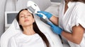 Elos epilation hair removal procedure on the face of a woman. Beautician doing laser rejuvenation on the forehead in a beauty Royalty Free Stock Photo