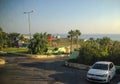 Elounda, Crete, Greece - September 2: Greek street, palm trees, children`s playground, the sea is visible in the distance