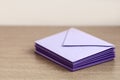 Elvelopes pile Group of purple envelopes on brown table