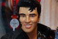 Elvis Presley figurine looking at camera. The figurine is shiny and a guitar is visible