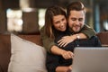 The email says that you got the job. an affectionate couple using a laptop while relaxing at home. Royalty Free Stock Photo