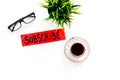 Email subscribe concept. Hand lettering subcribe on work desk with plant, glasses, cup of coffee on white background top