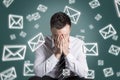 Email symbols swirling around an overstrained man