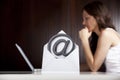 Emailing concept: At letter with woman and laptop.