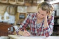 Emale apprentice taking notes in workshop Royalty Free Stock Photo