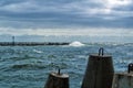 An embankment of Baltic sea at the city Baltiysk on cloudy summer day, a view to a mole, waves and big stone blocks at pier, the m Royalty Free Stock Photo