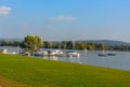 Embankment covered with green grass on a walk swans. In the distance there are boats in Lake Maggiore.