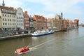 Tourists travel along canal in Gdansk. Boat-shaped pleasure boat cruise