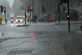 Flash flooding scene in central London with soaked people waiting at traffic lights and heavy rain Royalty Free Stock Photo