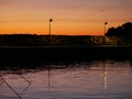 Embankment in the port. Yacht masts and ships sway on waves. Evening. Lantern Royalty Free Stock Photo