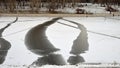 Embankment and thawed patches on snowy ice of lake large pond of Ochakovo Bolshoi Ochakovsky, Moscow, Russia