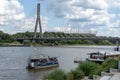 Embankment of the Vistula River in Warsaw. The ship is sailing. View of the bridge and the stadium. Sky with clouds.