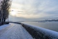 Embankment in winter. Dawn on the river. Winter river in the city. City embankment by the river on a sunny winter day with snow. Royalty Free Stock Photo