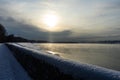 Embankment in winter. Dawn on the river. Winter river in the city. City embankment by the river on a sunny winter day with snow. Royalty Free Stock Photo