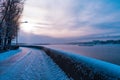 Embankment in winter. Dawn on the river. Winter river in the city. City embankment by the river on a sunny winter day with snow. Royalty Free Stock Photo