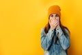 Embarrassed emotional astound woman in hat looks with frightened neurotic expression directly at camera