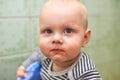 Embarrassed child sits on a stool with a dirty mouth after eating