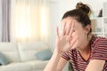 Embarrassed woman avoiding photo shoot at home