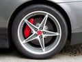 Kiev, Ukraine - 11 April; Emblem of Ferrari. Horse. Car wheels close up on a background of asphalt Royalty Free Stock Photo