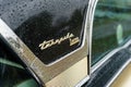 The emblem of full-size car Mercury Turnpike Cruiser in rain of drops, close-up.